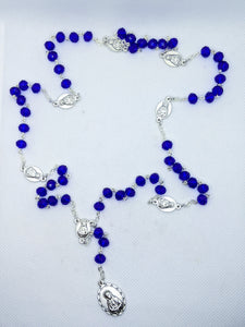 A royal blue 7 sorrows chaplet lays on a white background