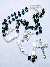 Load image into Gallery viewer, A deep blue mysteries rosary lays on a white background. 