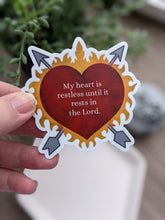 Load image into Gallery viewer, A hand is holding a heart surrounded by flames and pierced with 2 arrows shaped sticker