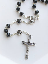 Load image into Gallery viewer, A close up on the black bead rosary and rose shaped pur father beads. It also shows the rose centerpiece and rose themed crucifix 
