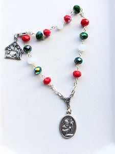 The red, green and white Christmas style St Andrew Novena Chaplet sits on a white background. 
