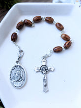 Load image into Gallery viewer, A wooden bead St Padre Pio 9 bead chaplet lays on a white tray on a wood background