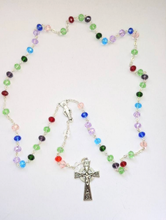 Load image into Gallery viewer, A family birthstone rosary features multiple colors to show each family members birth stone. It lays on a white background. 