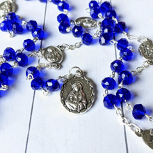 Load image into Gallery viewer, A royal blue seven sorrows chaplets lays on a whitewashed wooden background. 